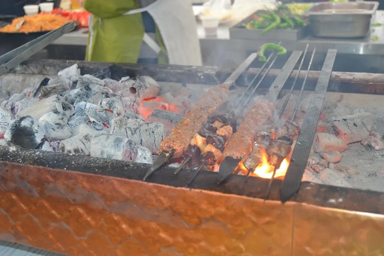 Adana kebap skewers grilling over charcoal