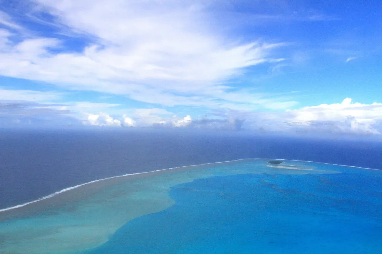 The turquoise lagoon and outer reef of Aitutaki seen from the air, Cook Islands
