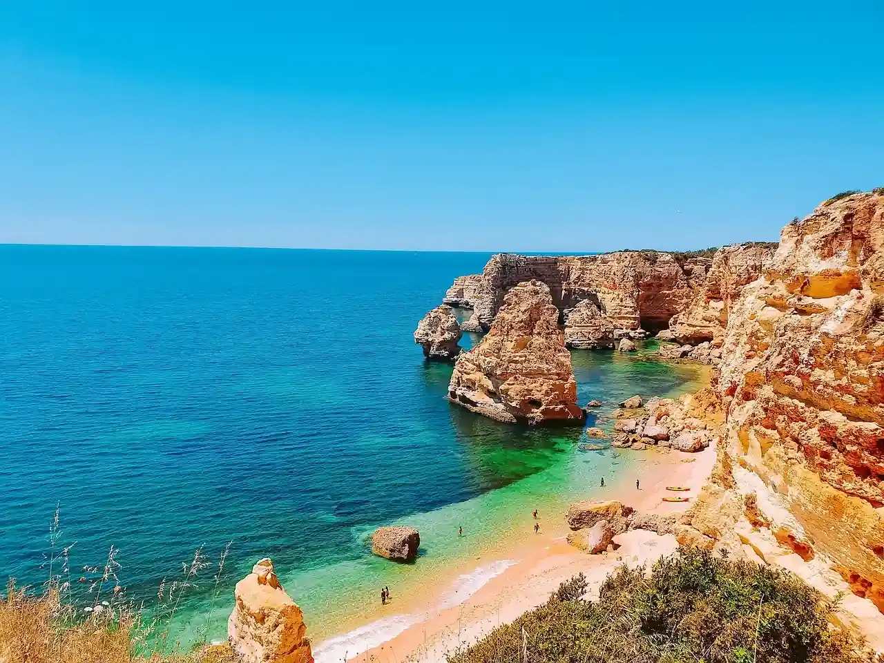 The ochre cliffs and sandy cove of Praia da Marinha on the Algarve coast