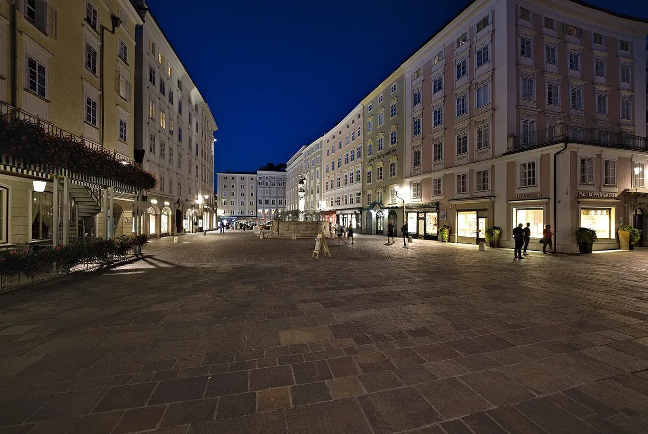 The Alter Markt square in Salzburg's old town at night, with lit shop fronts