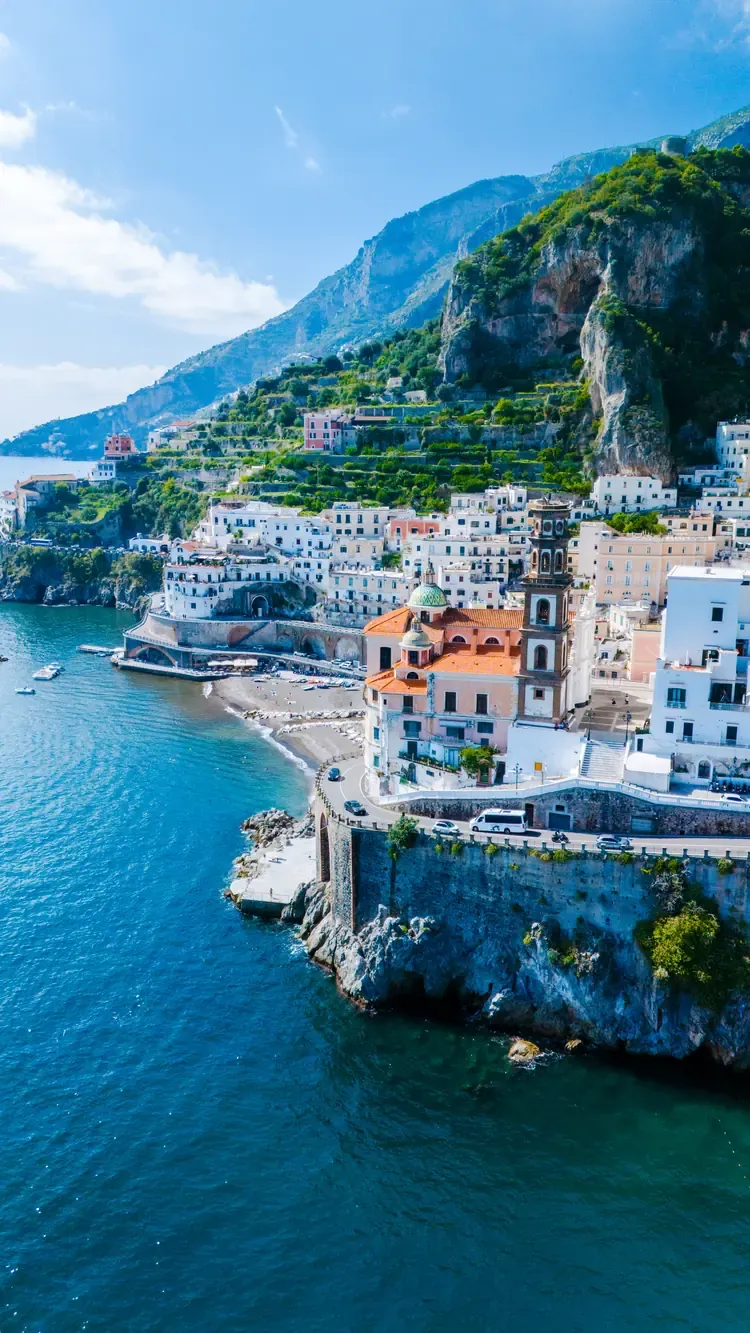 A clifftop village and cove along the Amalfi Coast, with terraced hillsides above
