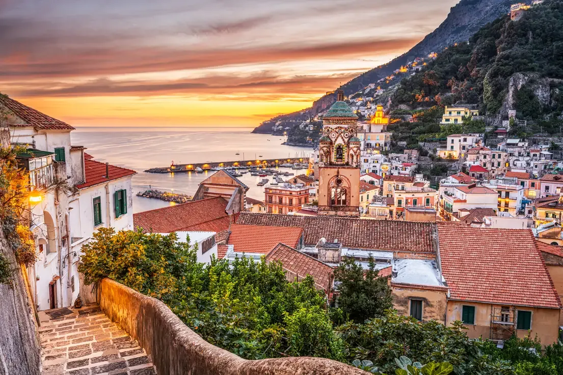 Amalfi's cathedral bell tower and clifftop houses at sunset on the Amalfi Coast