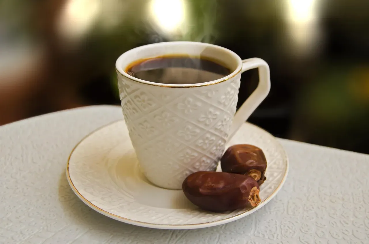 A cup of Arabic coffee served with dates