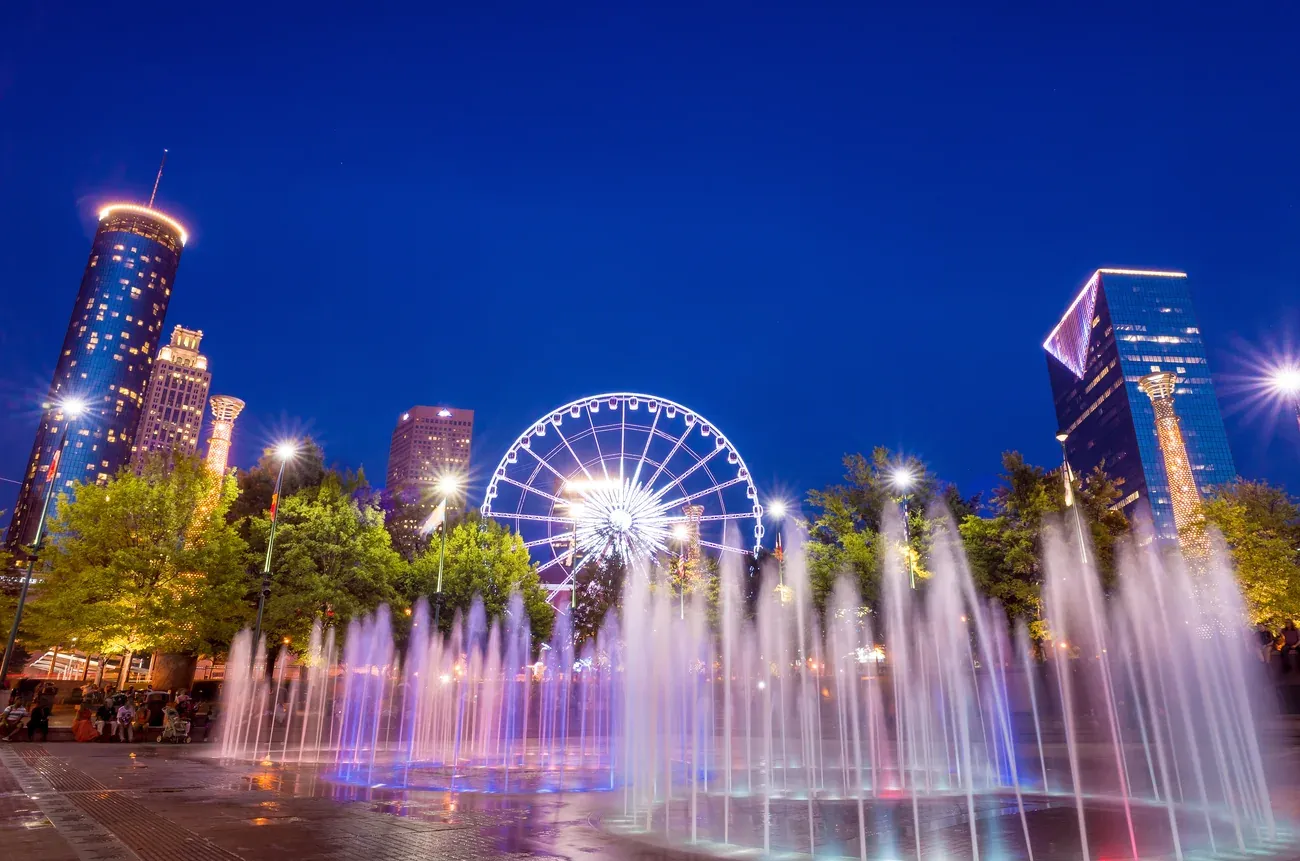 Illuminated fountain jets and the big wheel beside Centennial Olympic Park in Atlanta at night