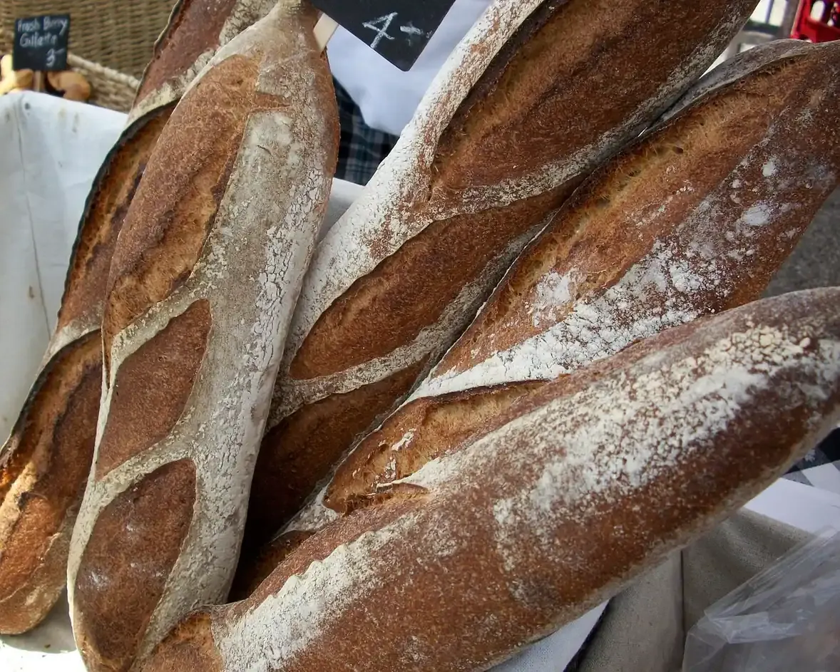 Crusty baguettes stacked on a rack in a French bakery