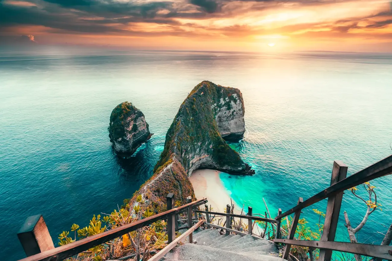 An aerial view of turquoise waves on the sands of Kelingking Beach on Nusa Penida, Bali