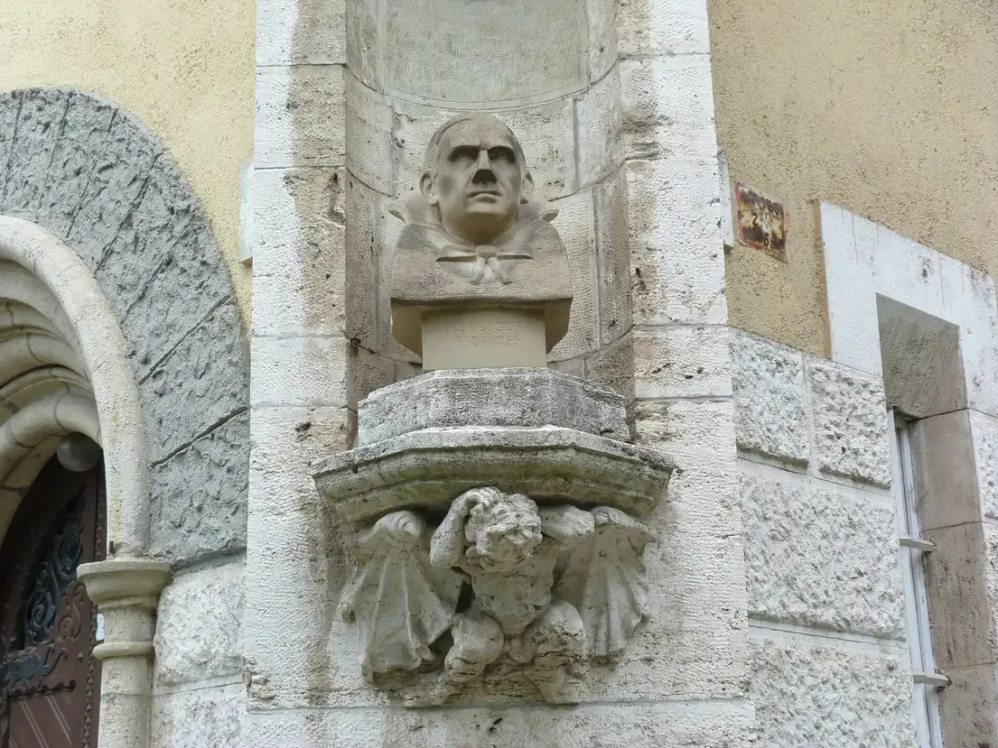 Stone bust of Bela Lugosi in a niche at the corner of a tower at Vajdahunyad Castle in Budapest City Park