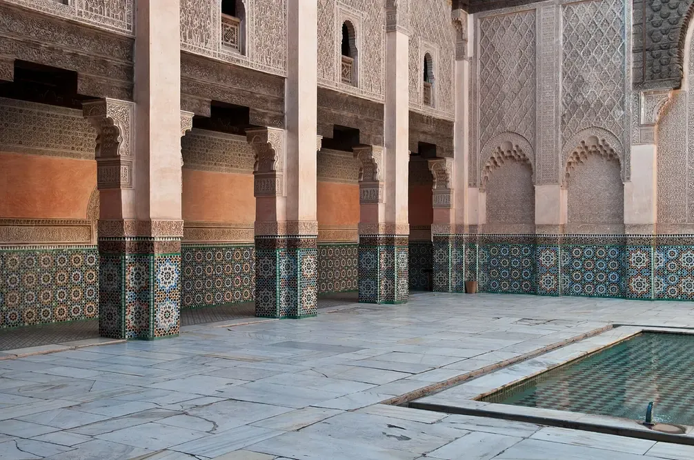 Carved colonnade and zellige tilework at the Ben Youssef Madrasa in Marrakech
