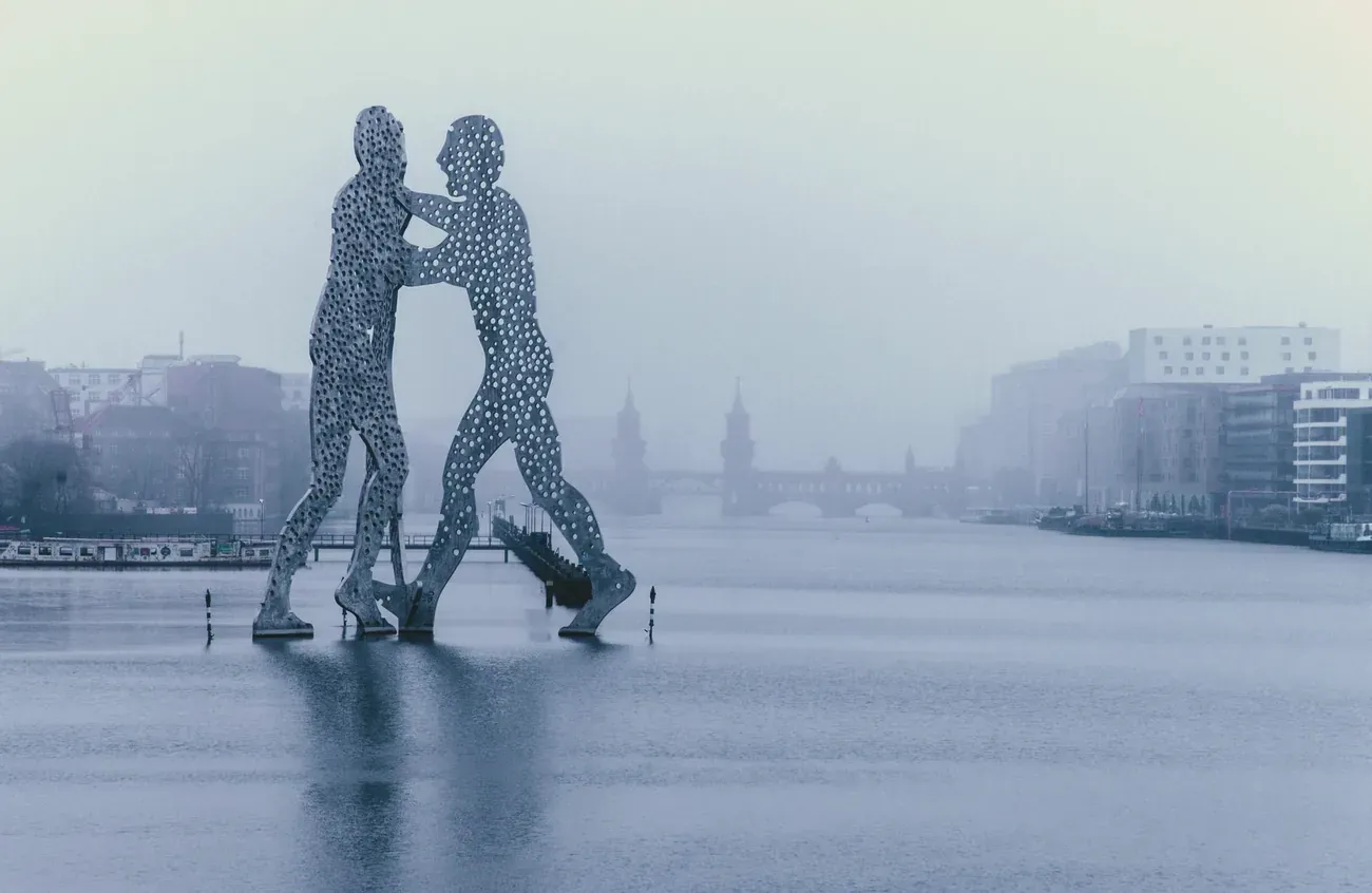 Molecule Man sculpture rising from the Spree on a misty day
