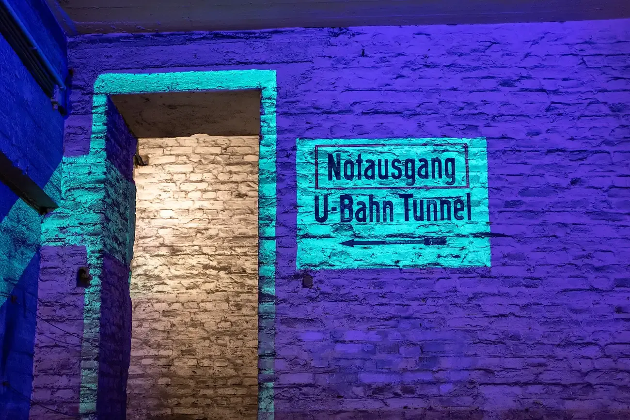 A lit Notausgang U-Bahn Tunnel sign on a Berliner Unterwelten guided tour beneath Berlin