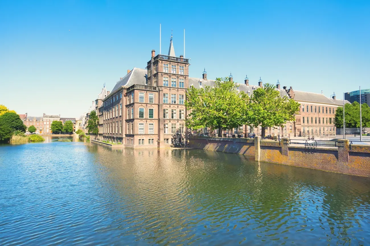 The Binnenhof reflected in the Hofvijver lake with a moored boat, The Hague