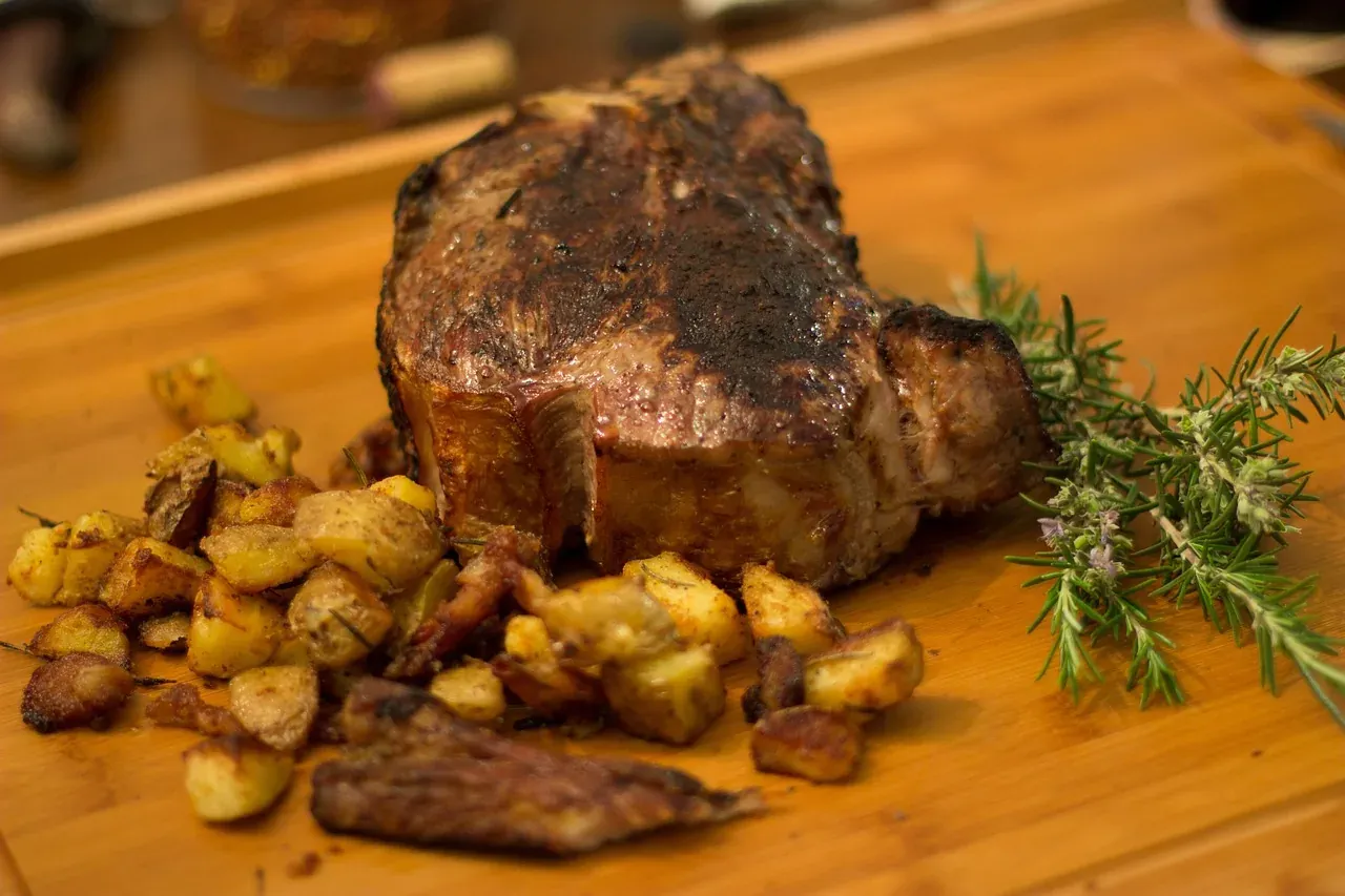 Bistecca alla fiorentina on a wooden board with rosemary