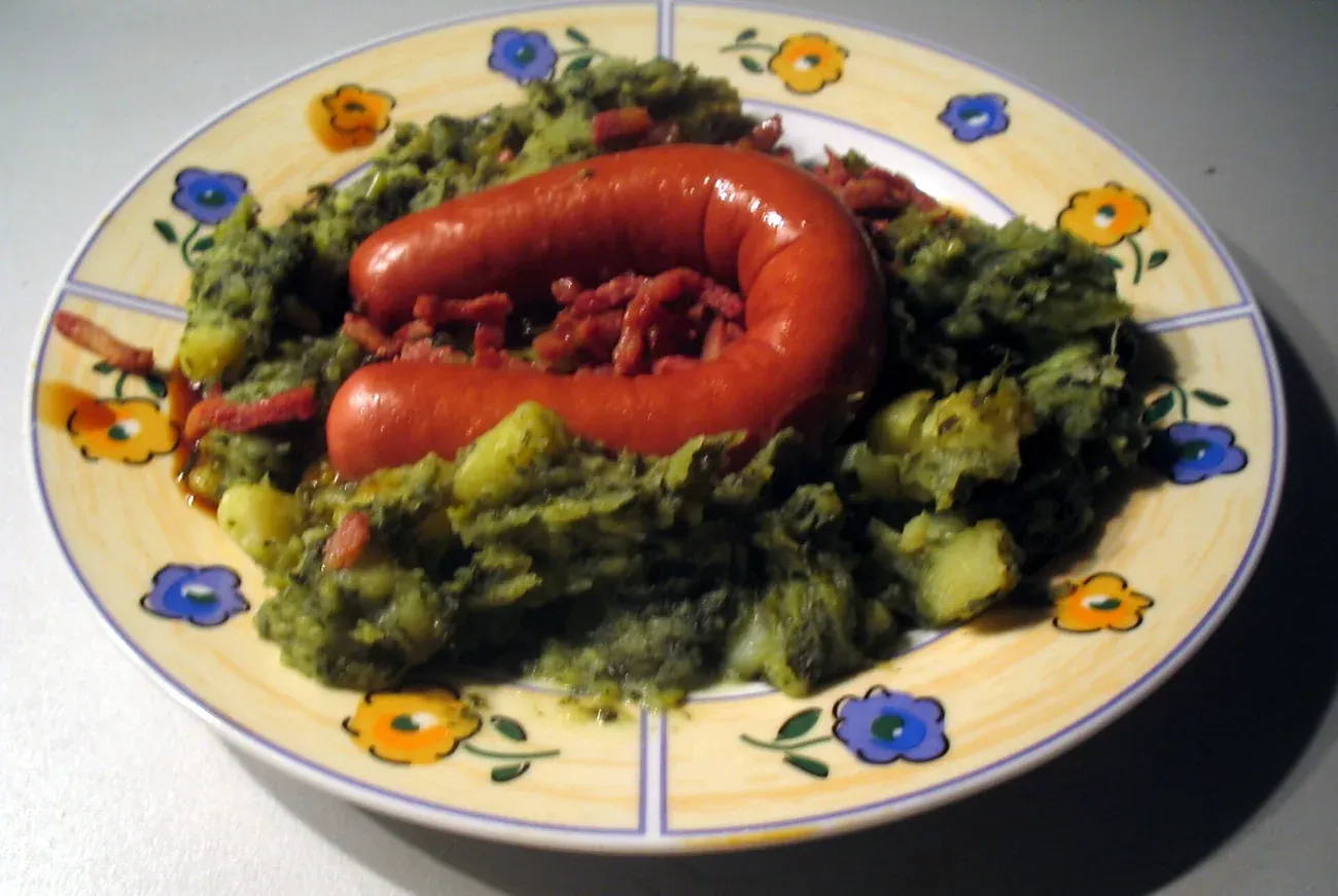 Boerenkool stamppot of mashed potato and kale served with smoked sausage