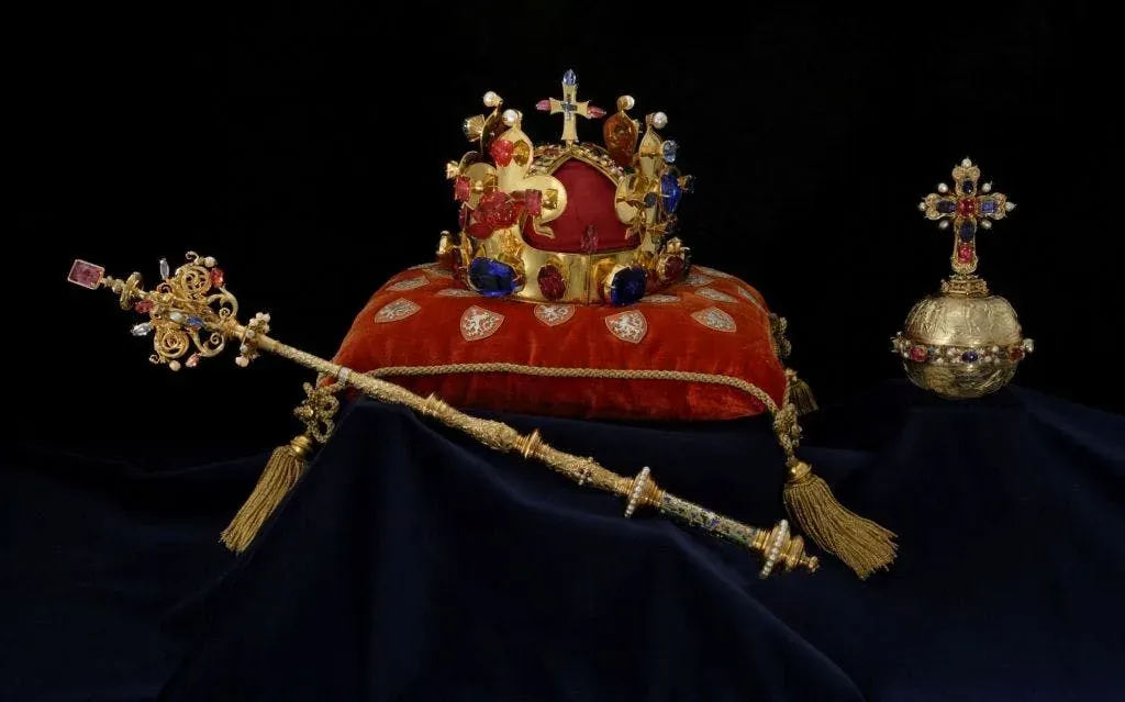 A crown and sceptre displayed on red velvet in Prague