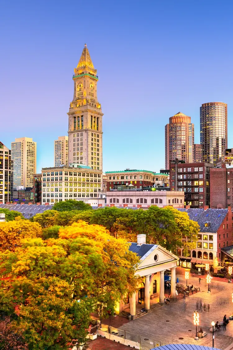 Custom House Tower rising above Quincy Market and autumn trees in Boston