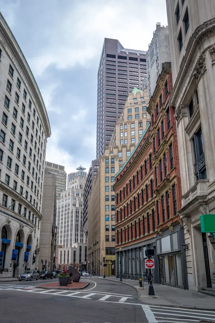 Quiet street framed by the stone and brick towers of Boston's Financial District
