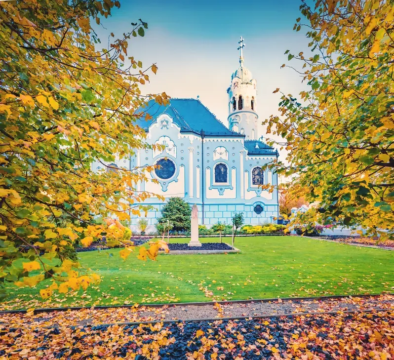 The Blue Church (Church of St. Elizabeth), Bratislava's art nouveau landmark, framed by autumn trees