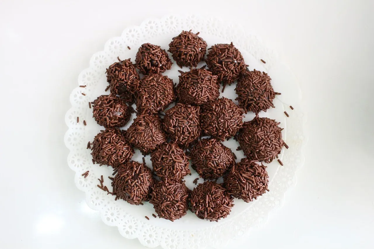 A plate of brigadeiro sweets rolled in chocolate sprinkles