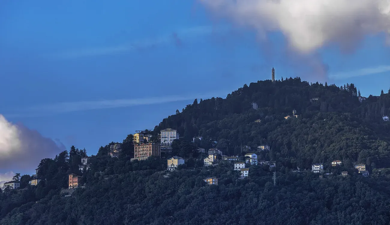 The houses of Brunate on the hilltop above Como with the Faro Voltiano on the summit