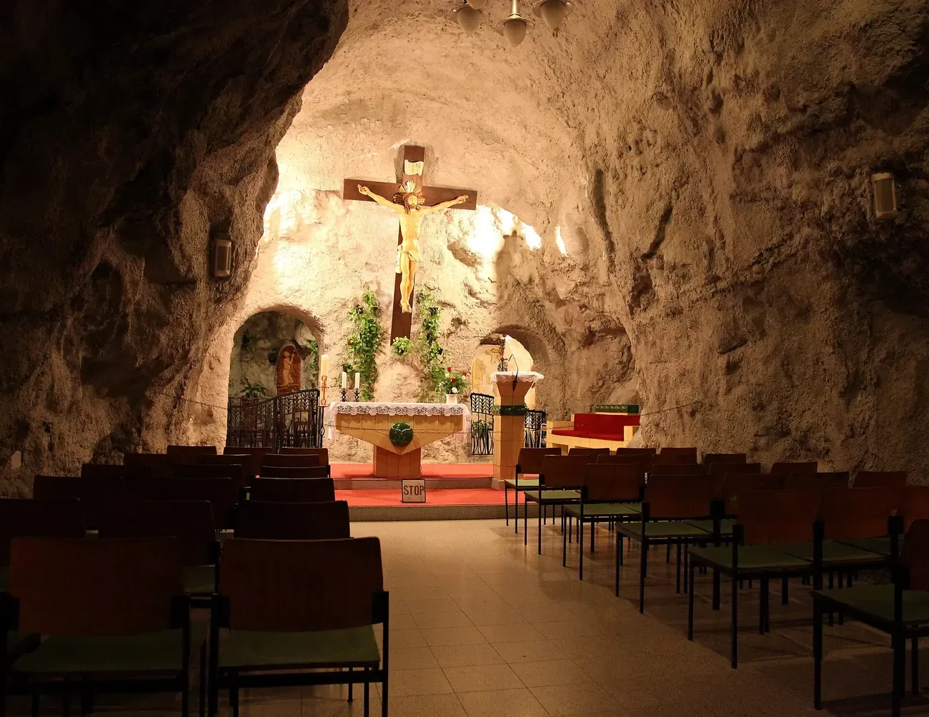 Interior of the Cave Church on Gellert Hill in Budapest with a crucifix above the altar and bare rock walls