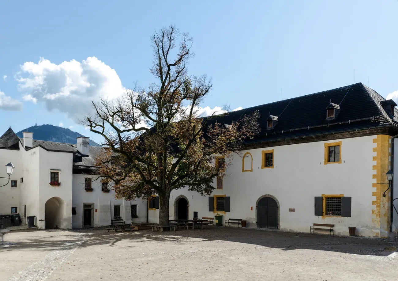 The large courtyard of Hohensalzburg Fortress in Salzburg with its lime tree and white buildings