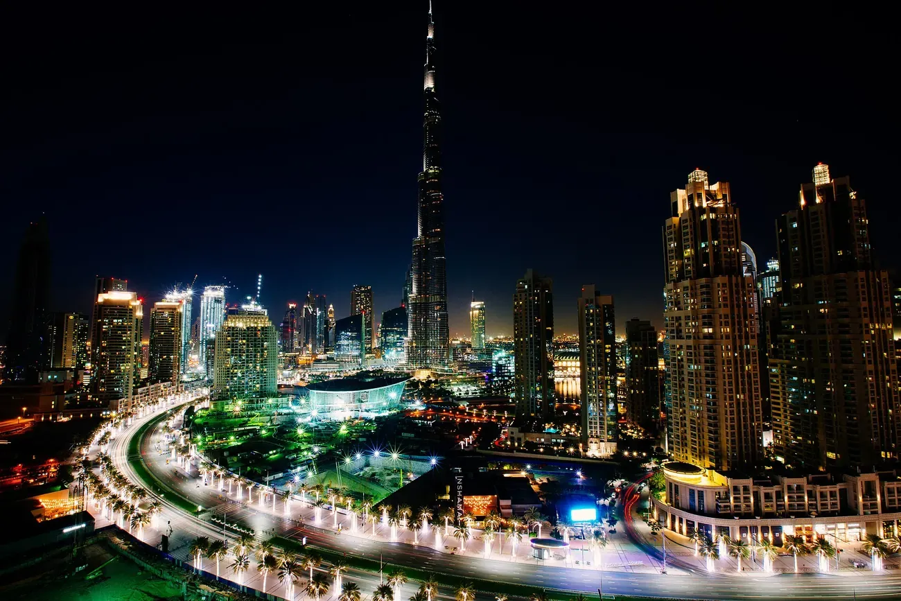 The Burj Khalifa lit at night above the towers of Downtown Dubai