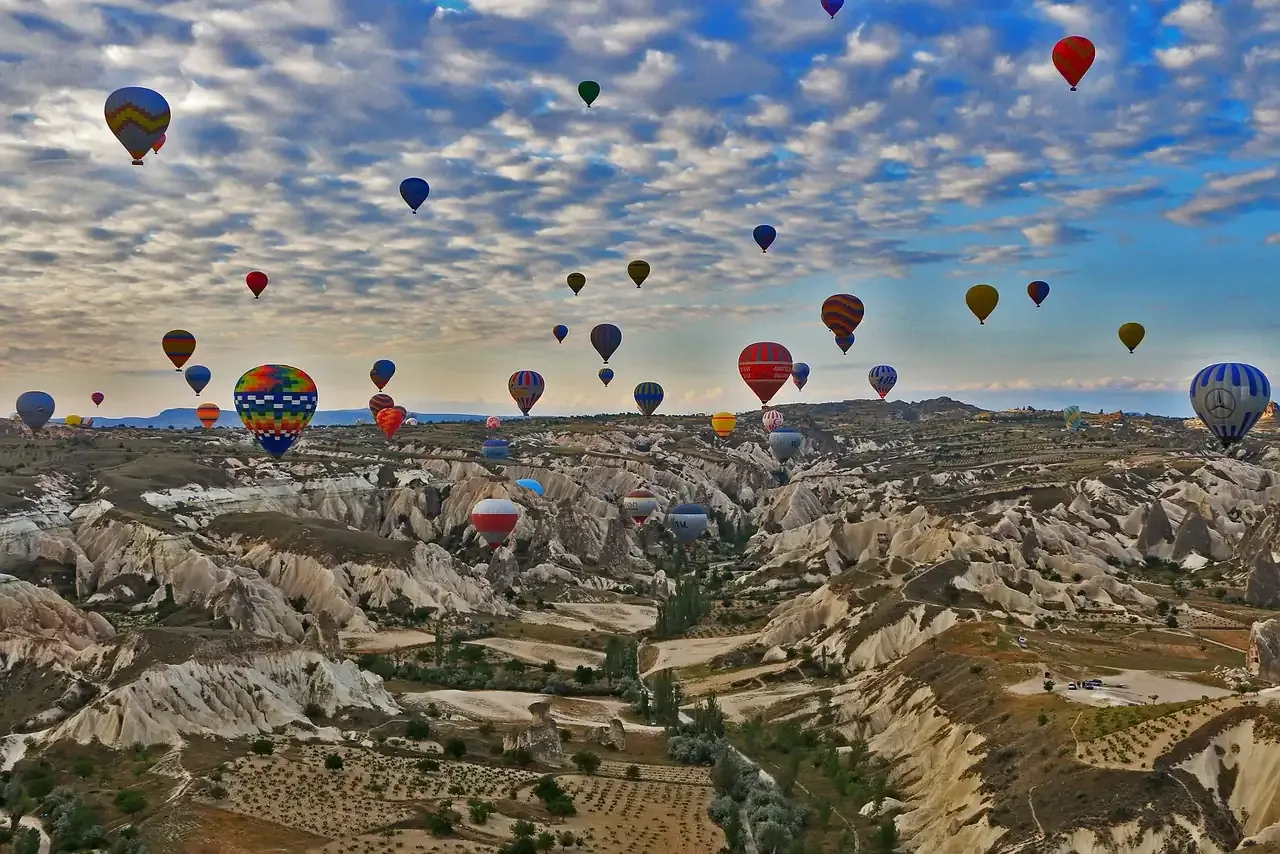 Panorama of balloons over the orchards and tuff valleys of Cappadocia