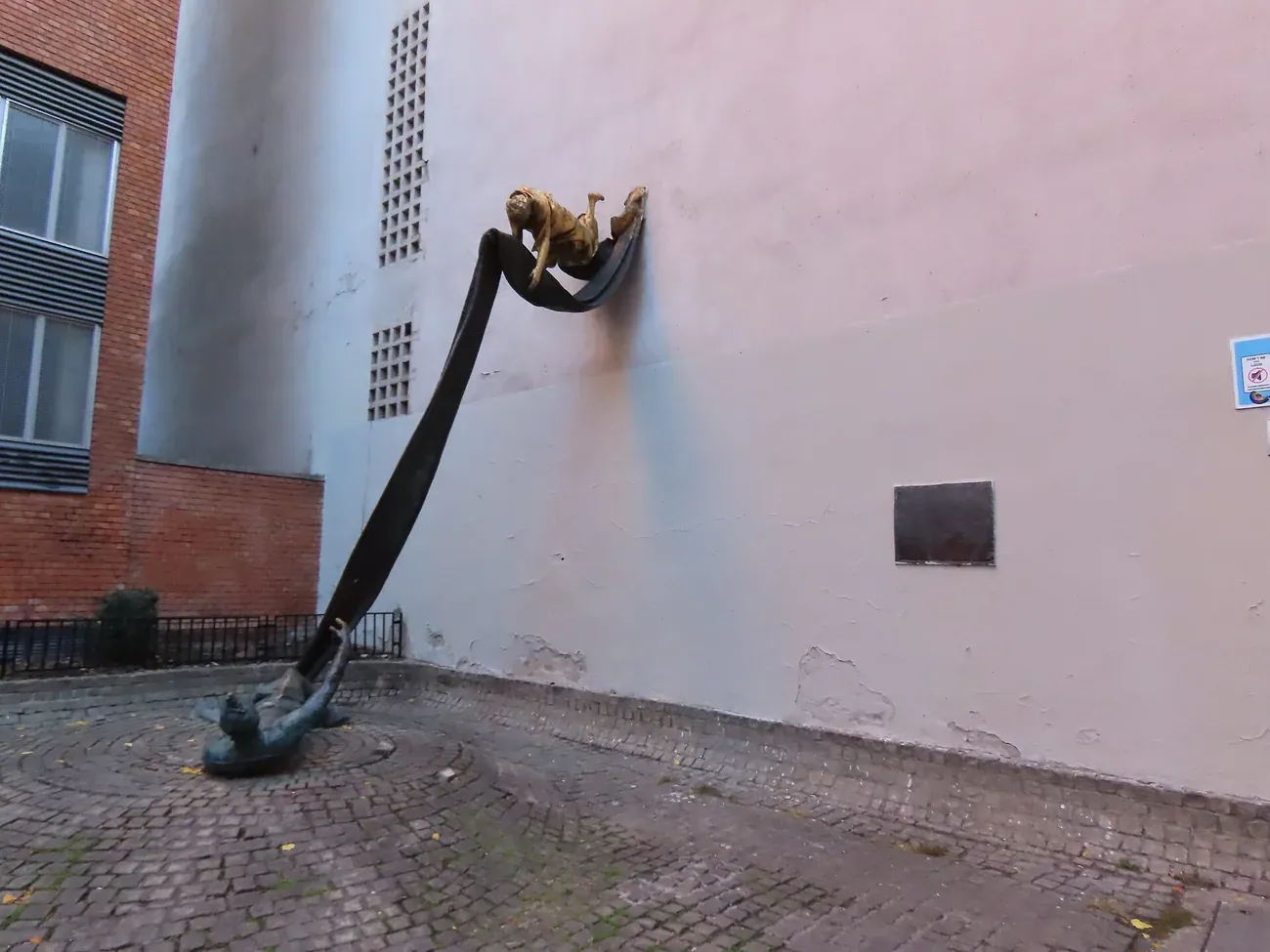 The gilded figure on the wall and the fallen figure below at the Carl Lutz Memorial on Dob utca in Budapest