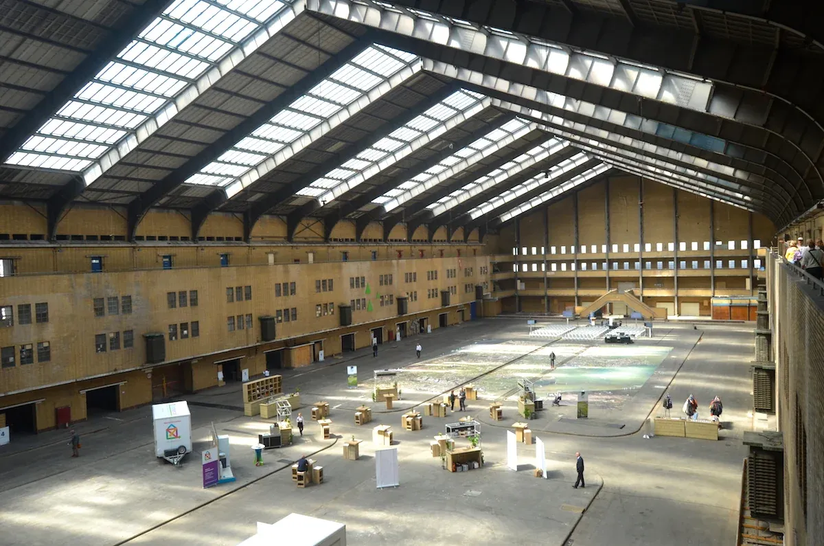 The interior of the Centrale Markthal in Amsterdam-West, a long hall with a skylit roof and stands set out on the floor