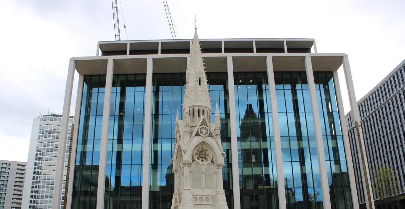 The Chamberlain Memorial spire before a glass building at Paradise, Birmingham