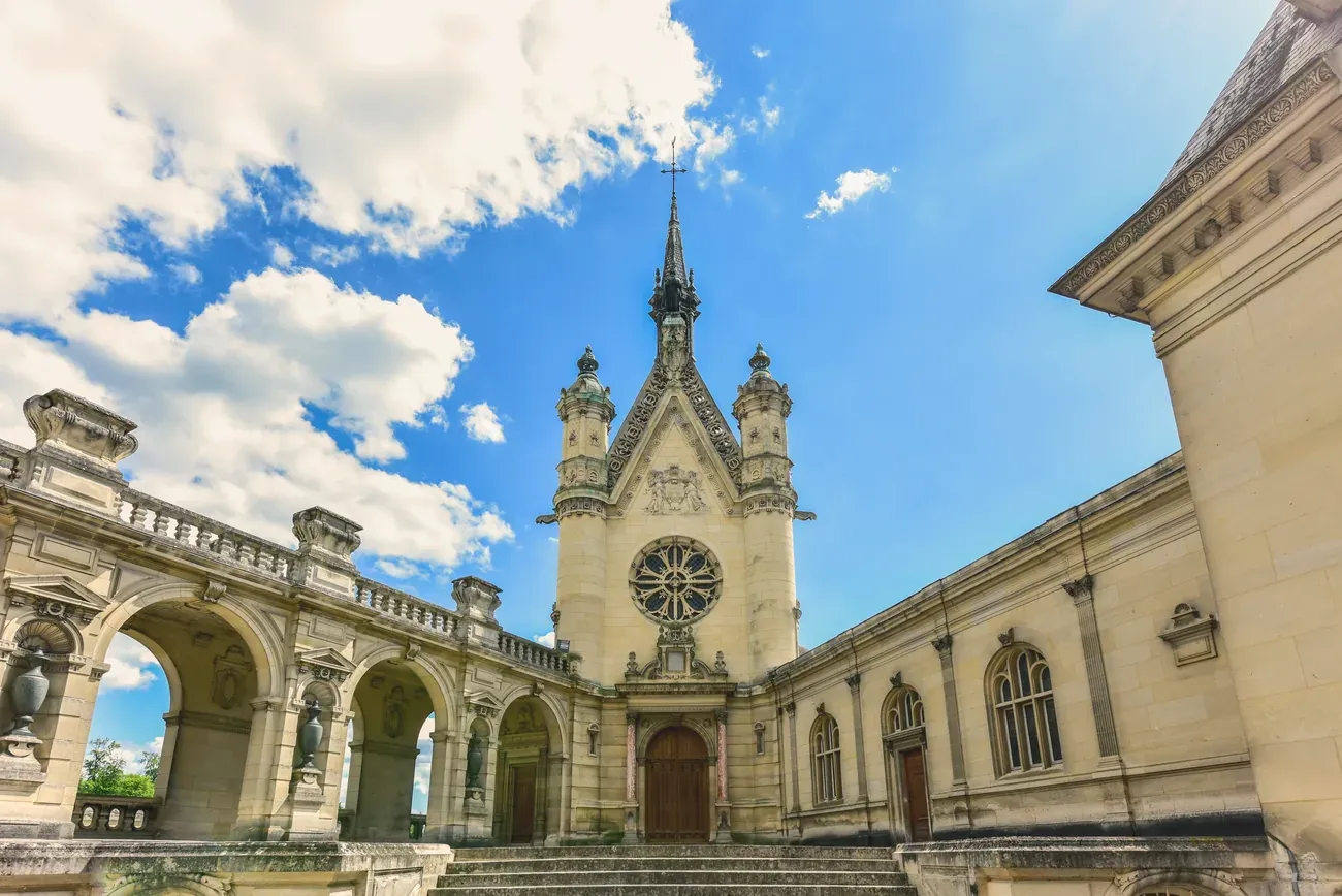 Exterior of the chapel at Chateau de Chantilly under a clear blue sky