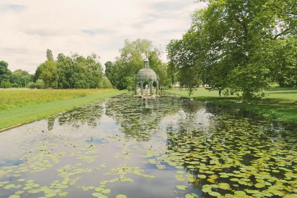 The cast-iron Temple of Venus on the lily-covered water of the English garden at Chantilly, France