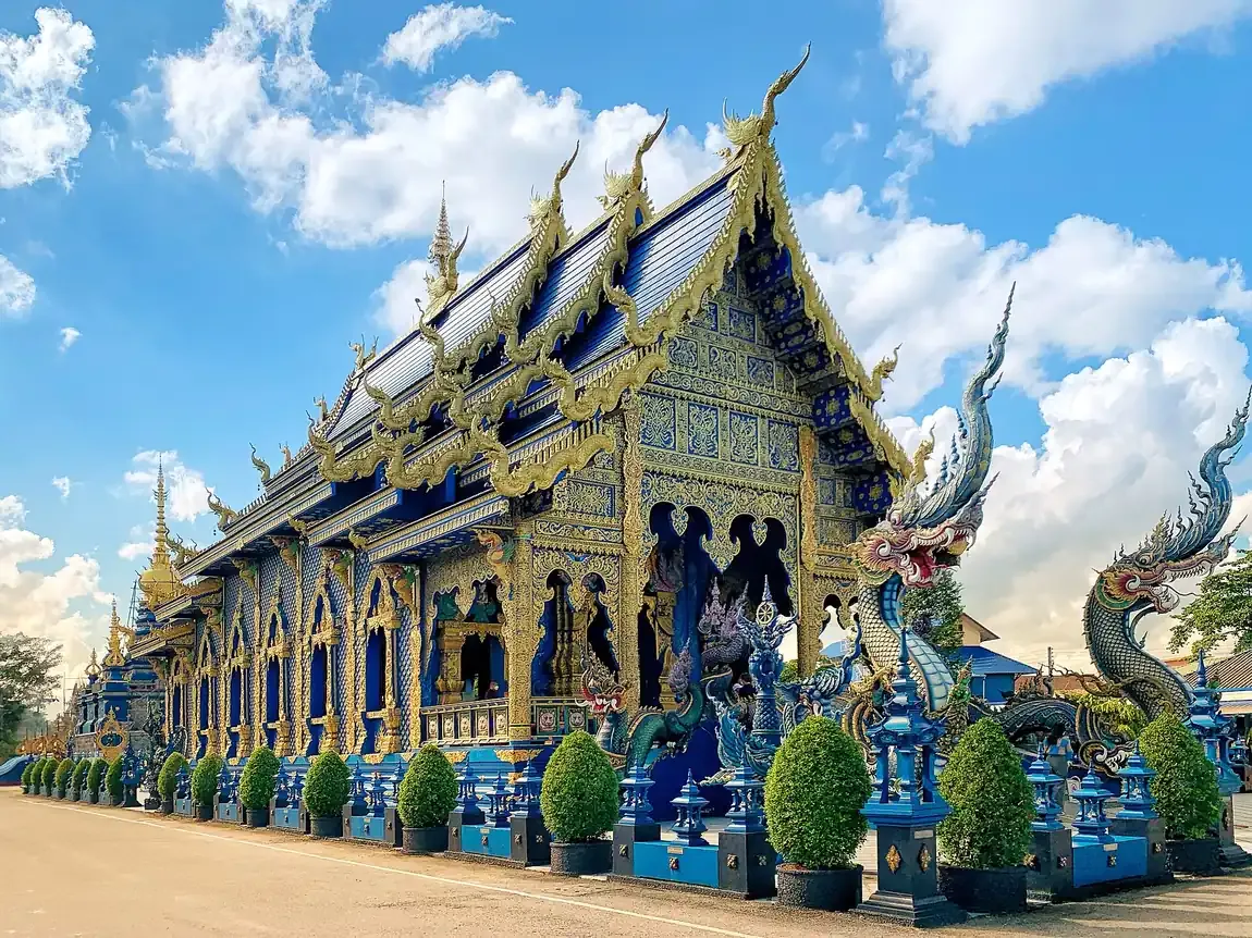 The blue and gold exterior of Wat Rong Suea Ten in Chiang Rai