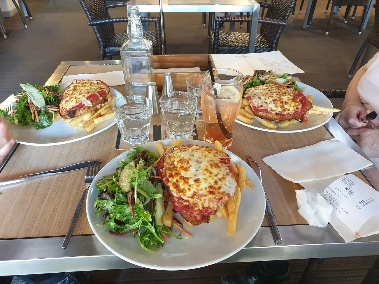 A chicken parmigiana served with chips and salad in an Australian pub