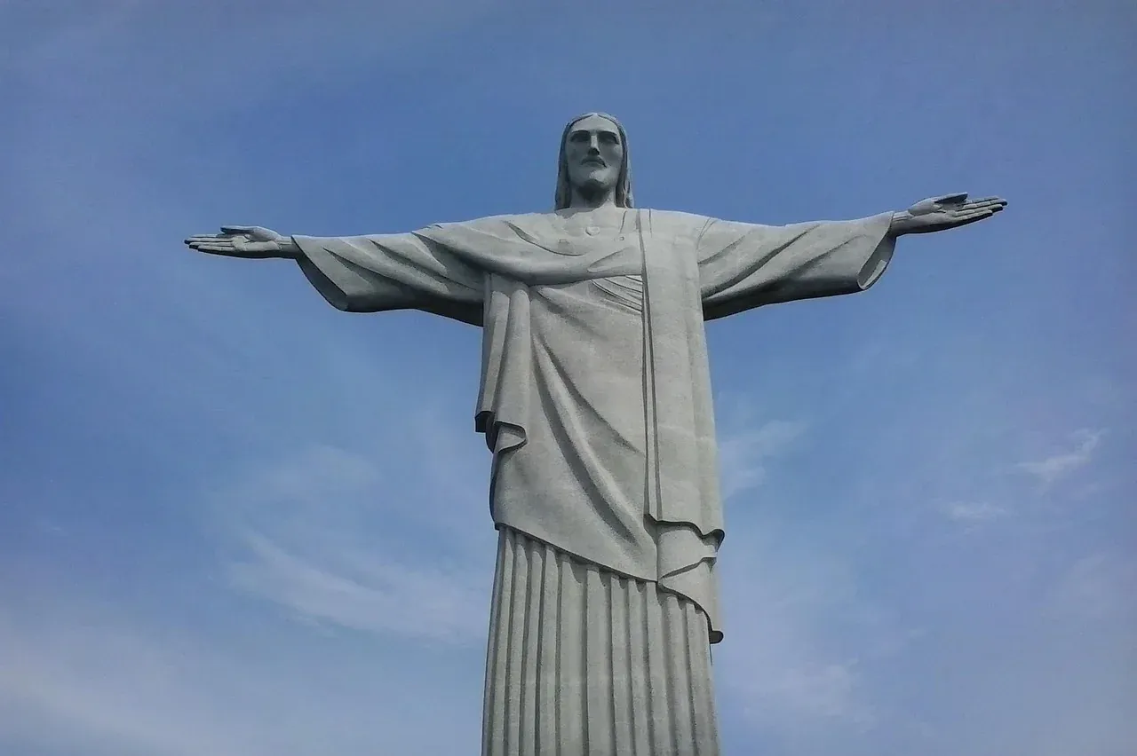 The Christ the Redeemer statue with its arms open against the sky above Rio de Janeiro