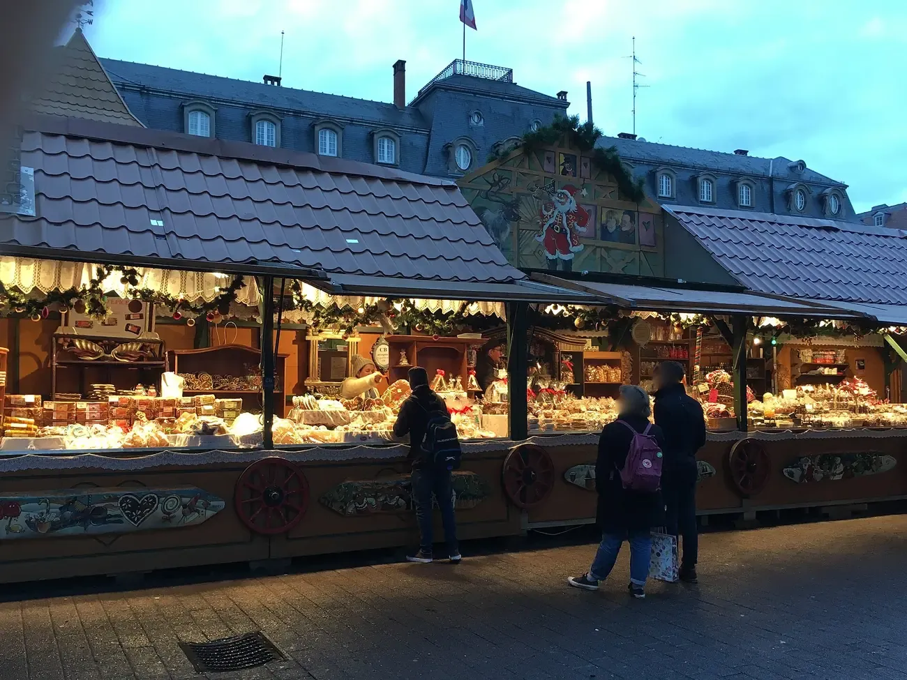 Lit Christmas market chalets on place Broglie in Strasbourg at dusk