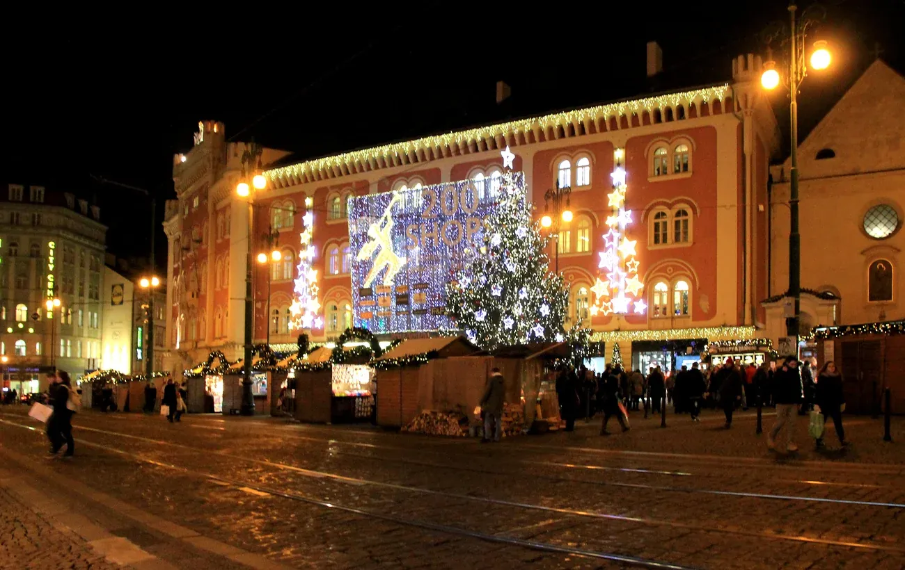 Christmas huts and a lit tree in front of the Palladium building on náměstí Republiky, Prague
