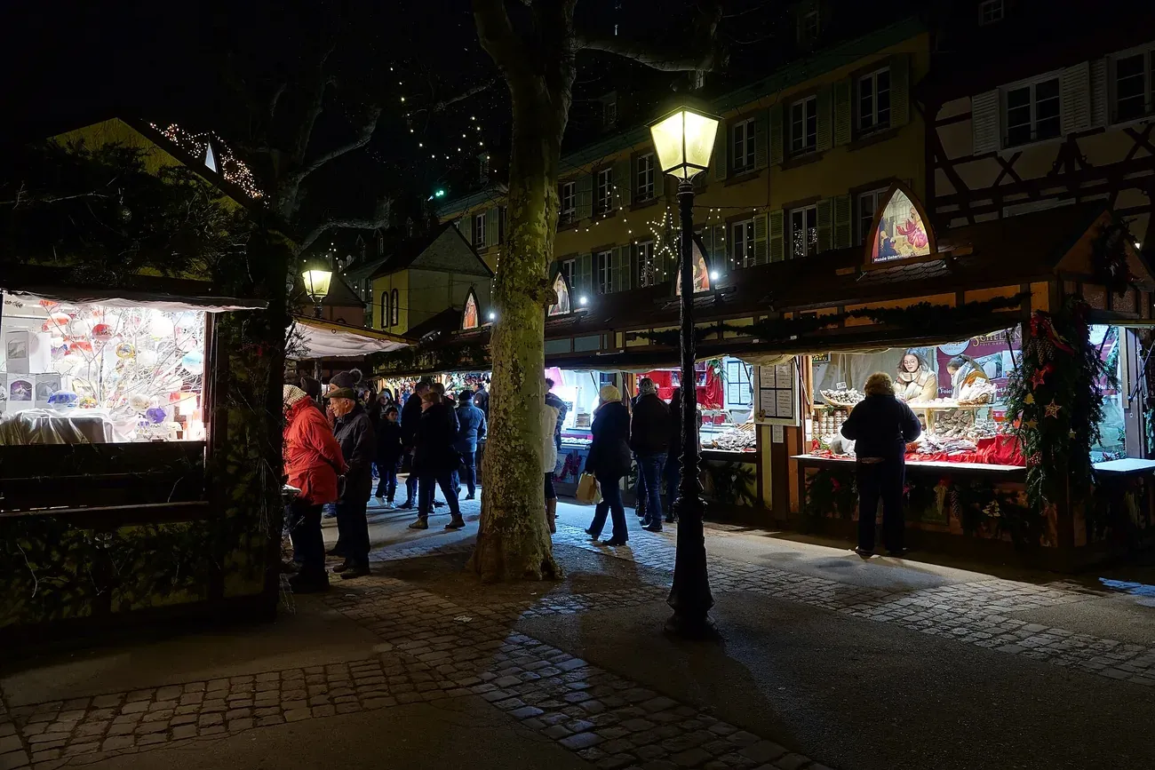 Lit chalets of the Christmas market on place des Dominicains in Colmar at night