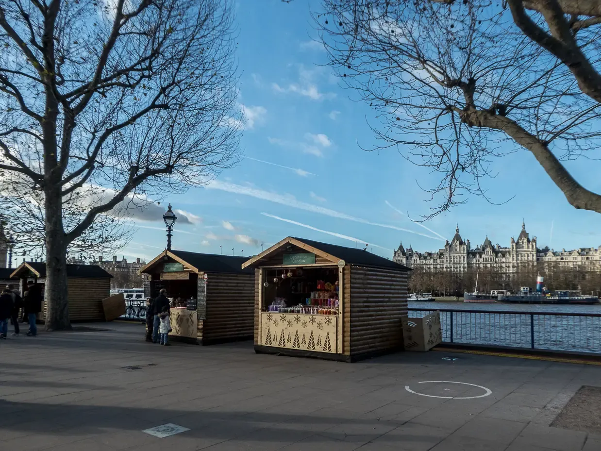Wooden Christmas market chalets on the Queen's Walk by the Thames on the South Bank, London