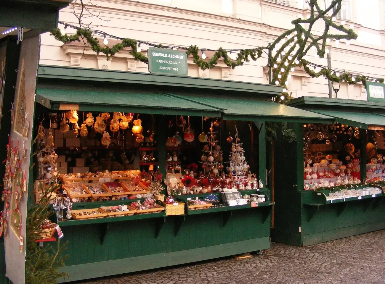 A green wooden stall full of Christmas decorations at the Christmas market on Mirabellplatz in Salzburg