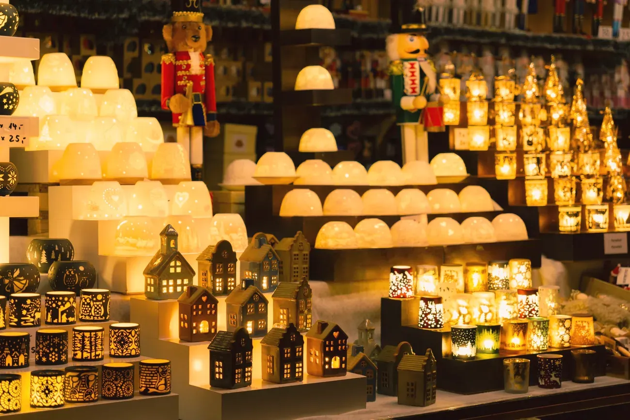 Christmas market stall glowing with candle lanterns and small ceramic houses