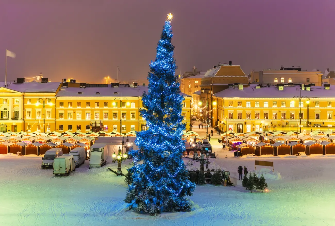 Christmas market stalls and the lit Christmas tree on a snowy Senate Square in Helsinki