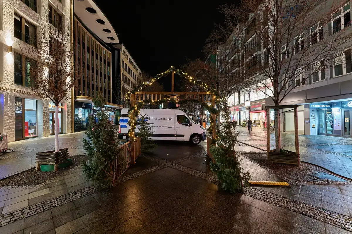 A lit arch and Christmas trees in the Wilmersdorfer Straße pedestrian zone during the Christmas market, Berlin