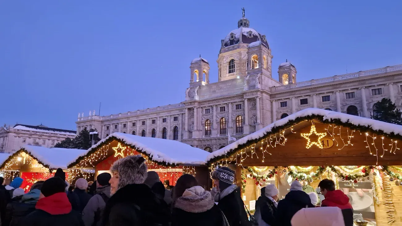 Snow-covered Christmas market huts in front of the Natural History Museum on Maria-Theresien-Platz, Vienna