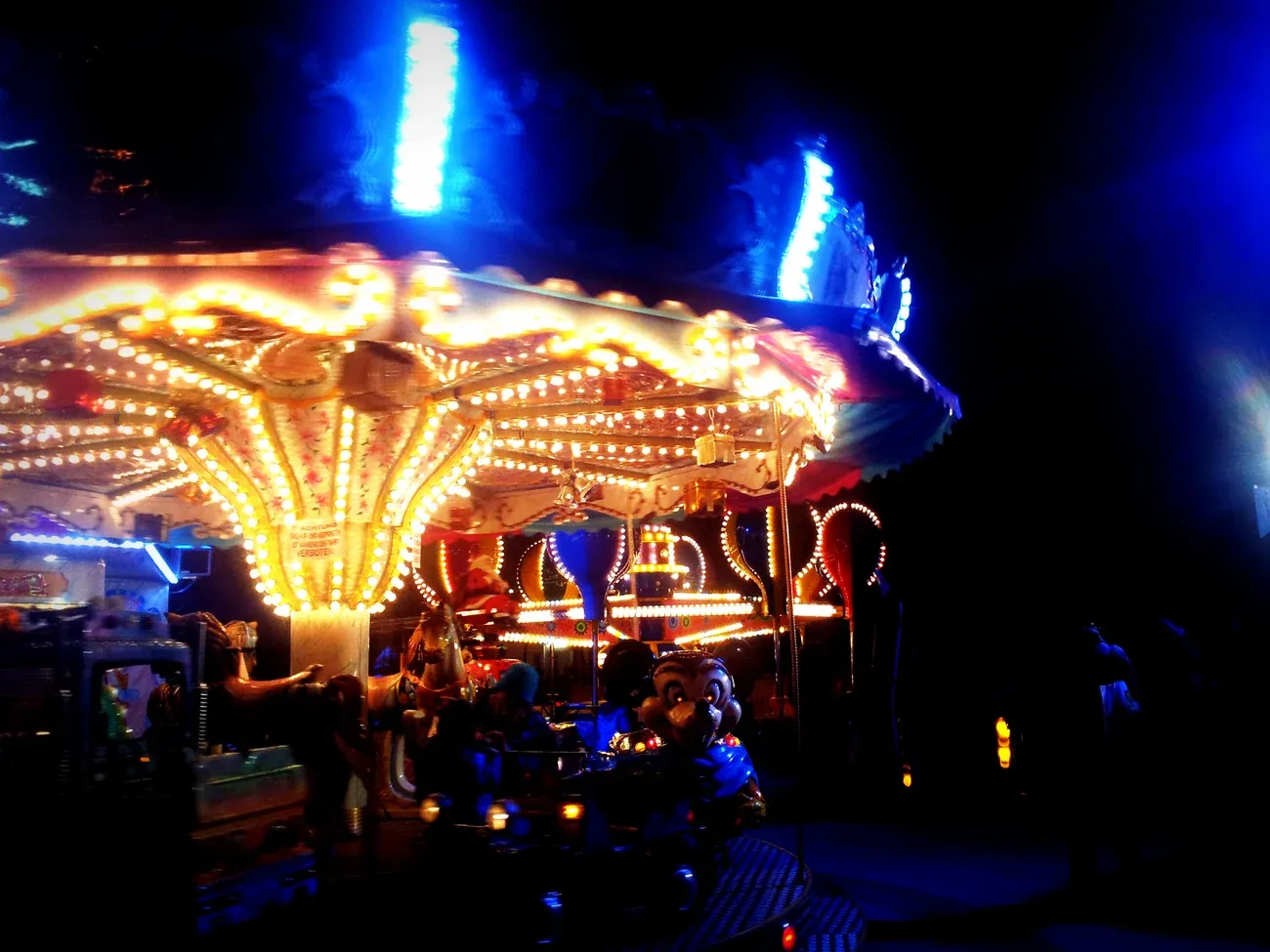 Lit carousel at the Christmas village on the University of Vienna Campus (Altes AKH) at night