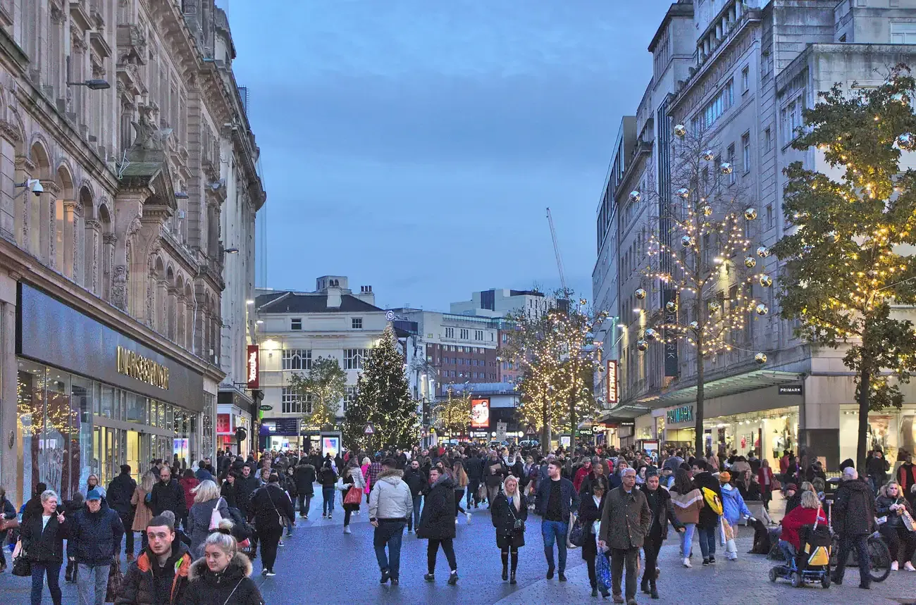 Shoppers on Church Street in Liverpool city centre at Christmas, with lit trees along the pedestrian street