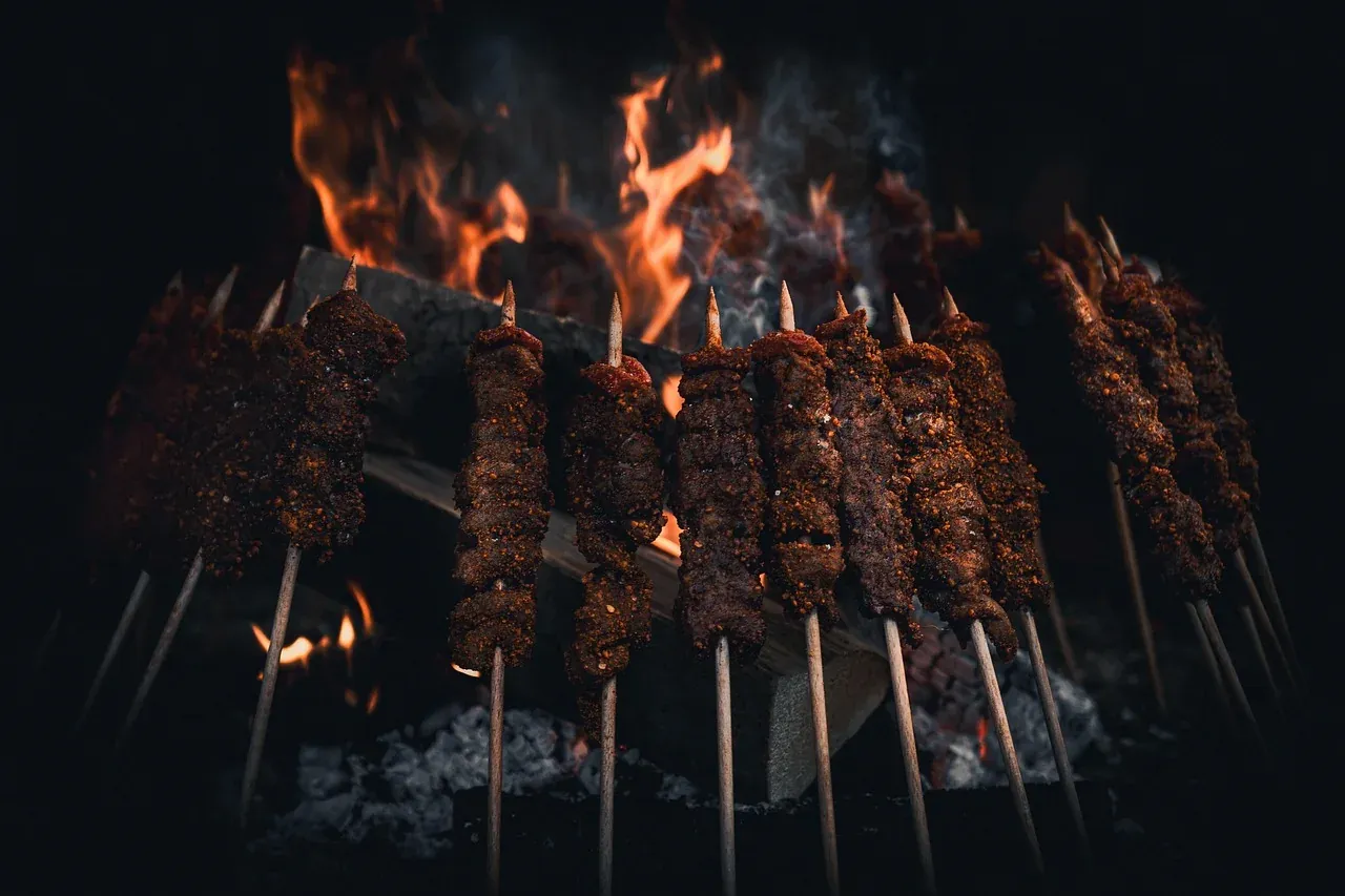 Cuts of beef on steel spits roasting over embers at a churrasco