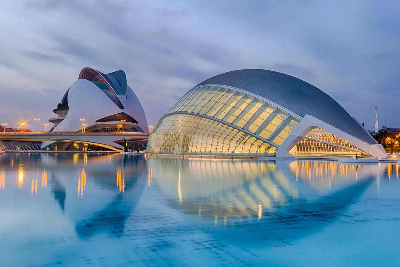 The Hemisferic and the Palau de les Arts reflected in the pools of the City of Arts and Sciences in Valencia at dusk