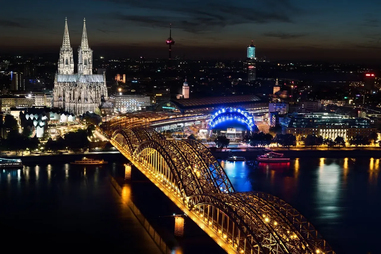 Cologne Cathedral and the Hohenzollern Bridge lit at night in Cologne