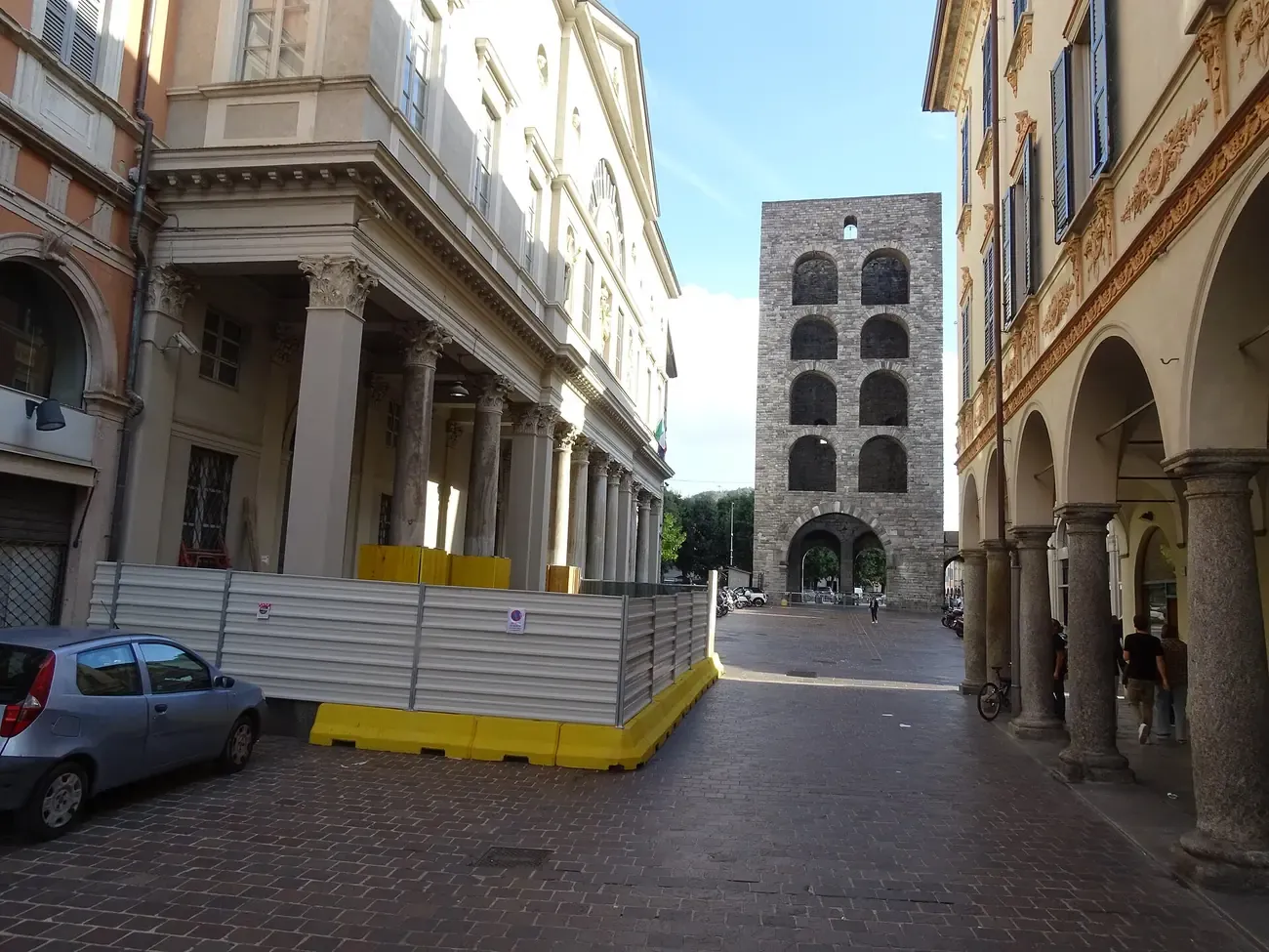 The medieval Porta Torre gate tower at the end of an arcaded street in Como